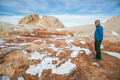 Man contemplates winter at white pocket /vermilion cliffs, northern az