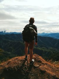 Rear view of man standing on mountain road