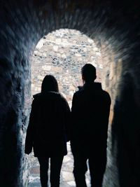 Rear view of silhouette people standing in tunnel