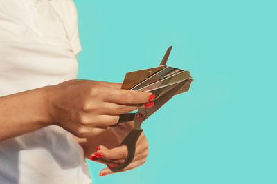 Close-up of woman holding hands against blue background