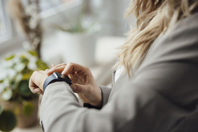 Businesswoman checking smart watch in office