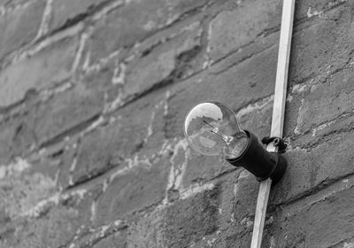 Low angle view of light bulb on wall