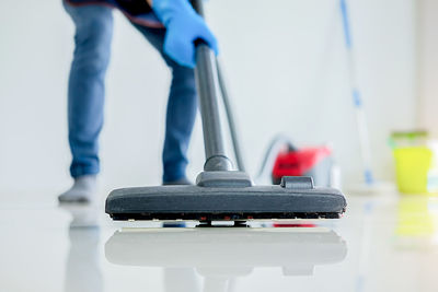 Low section of man cleaning tiled floor at home