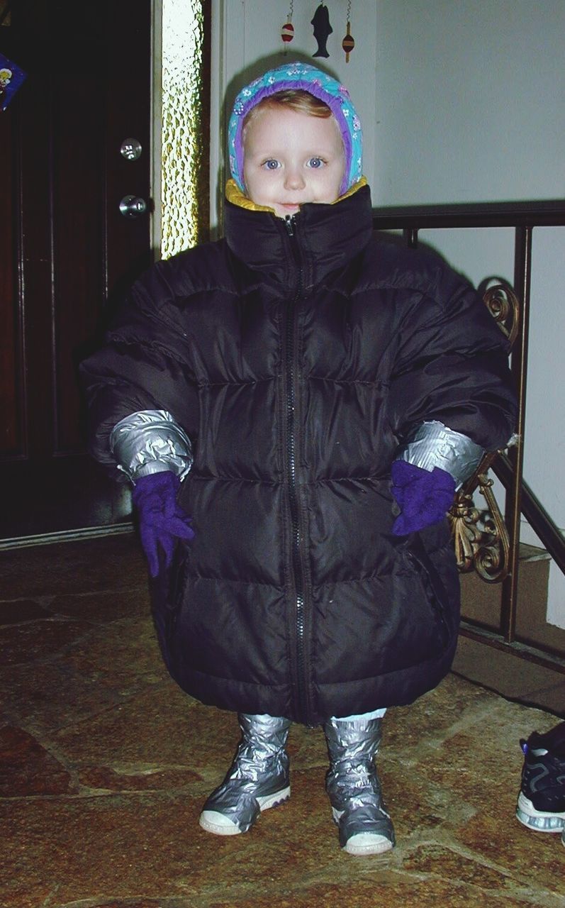 FULL LENGTH PORTRAIT OF BOY STANDING IN CORRIDOR