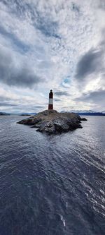 Lighthouse by sea against sky