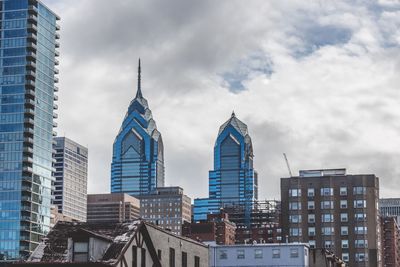 Low angle view of buildings against cloudy sky