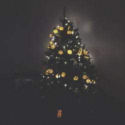 Low angle view of illuminated christmas tree against sky at night