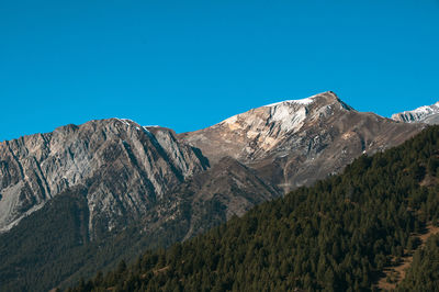 Scenic view of rocky mountains against clear blue sky