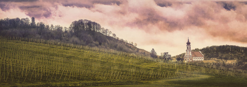 View of field against cloudy sky