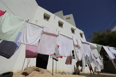 Low angle view of clothes drying on clothesline against building