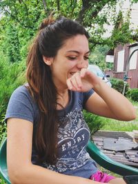 Portrait of a smiling young woman sitting outdoors