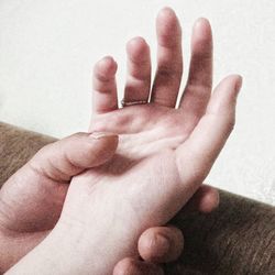 Close-up of hands against wall