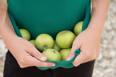 Midsection of woman holding apple