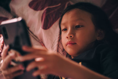 Close-up of young woman holding mobile phone