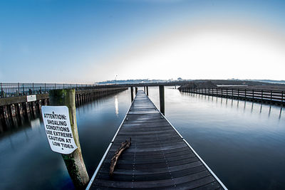 Pier over river against clear sky