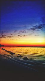 Scenic view of sea against dramatic sky during sunset