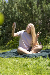 Portrait of young woman sitting on field