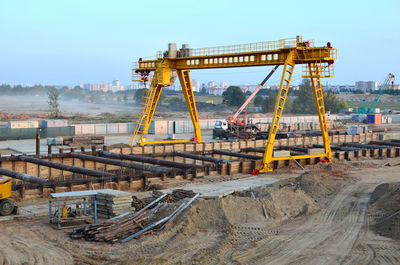 Cranes at construction site against sky