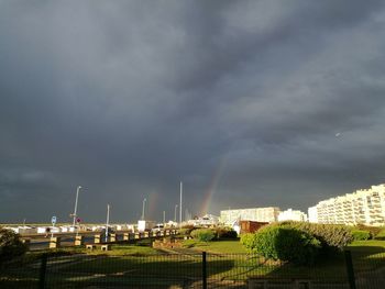 Buildings in city against cloudy sky