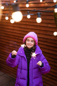 Portrait of young woman in puff with sparklers in her hands smiling cute