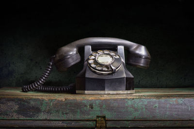 Close-up of old telephone booth on table