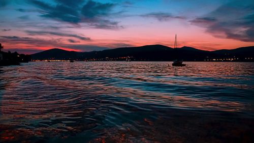 Scenic view of sea against dramatic sky during sunset