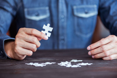 Midsection of person holding jigsaw puzzle