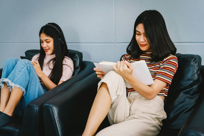 Young woman sitting on sofa