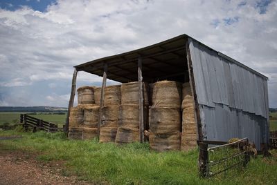 Stack of hay on field against sky