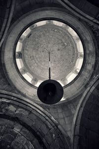 Low angle view of electric lamp hanging on ceiling in building