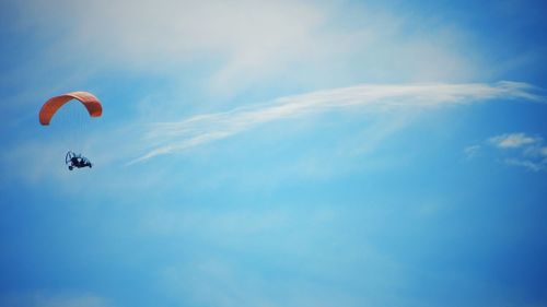 Low angle view of parachute flying against sky