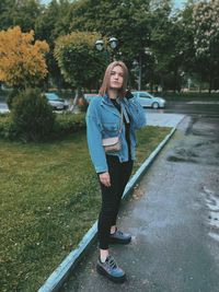 Portrait of smiling young woman standing on tree