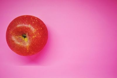 High angle view of apple against pink background