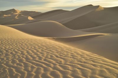 Sand dunes in desert against sky