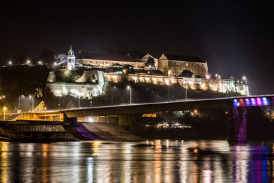 Illuminated bridge over river at night