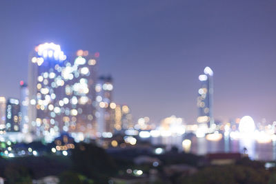 Defocused image of illuminated city buildings at night