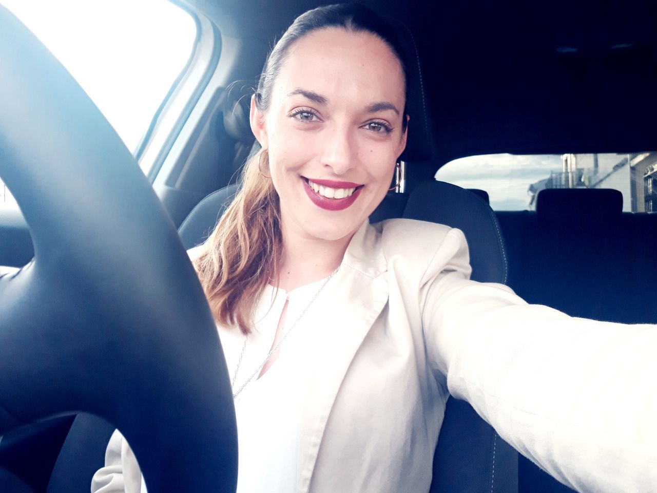 PORTRAIT OF HAPPY WOMAN SITTING IN CAR