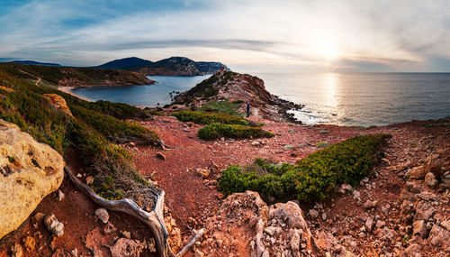 Scenic view of sea and mountains against sky