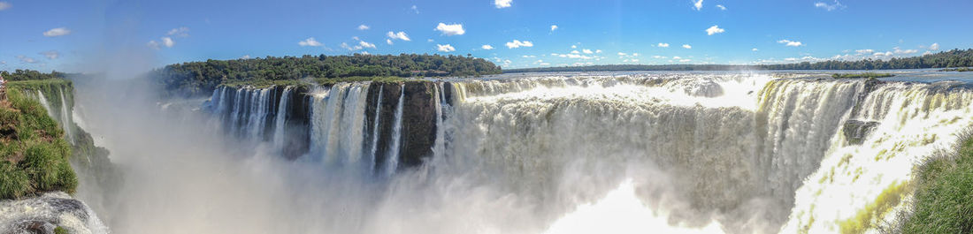 Panoramic view of iguazu falls against sky
