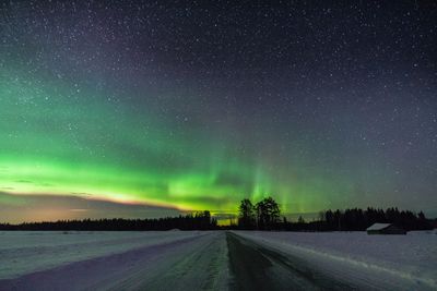 Scenic view of road against sky at night during winter