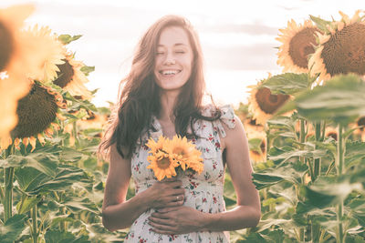 Portrait of smiling young woman against bright sun