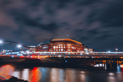 Illuminated bridge over river against sky at night