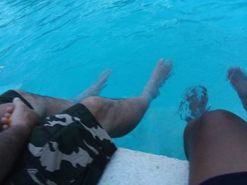 Low section of woman legs in swimming pool