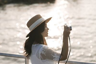 Portrait of woman holding hat in water