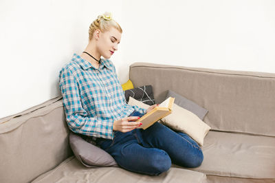 Young woman sitting on sofa at home