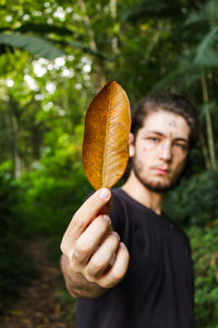 Close-up of hand holding leaf