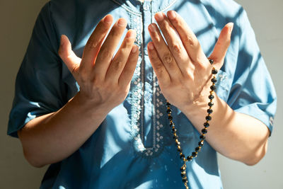 Muslim man praying with rosary on hand palm