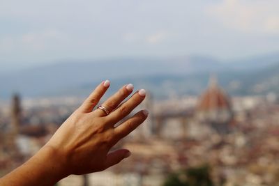 Close-up of woman hand against sky