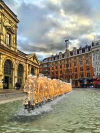 Buildings against cloudy sky