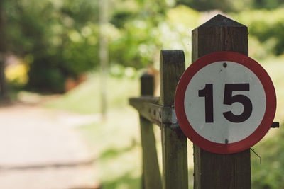 Close-up of road sign on wooden post